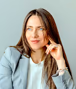 Portrait of Eva Kutzler resting her hand near her face against a grey background
