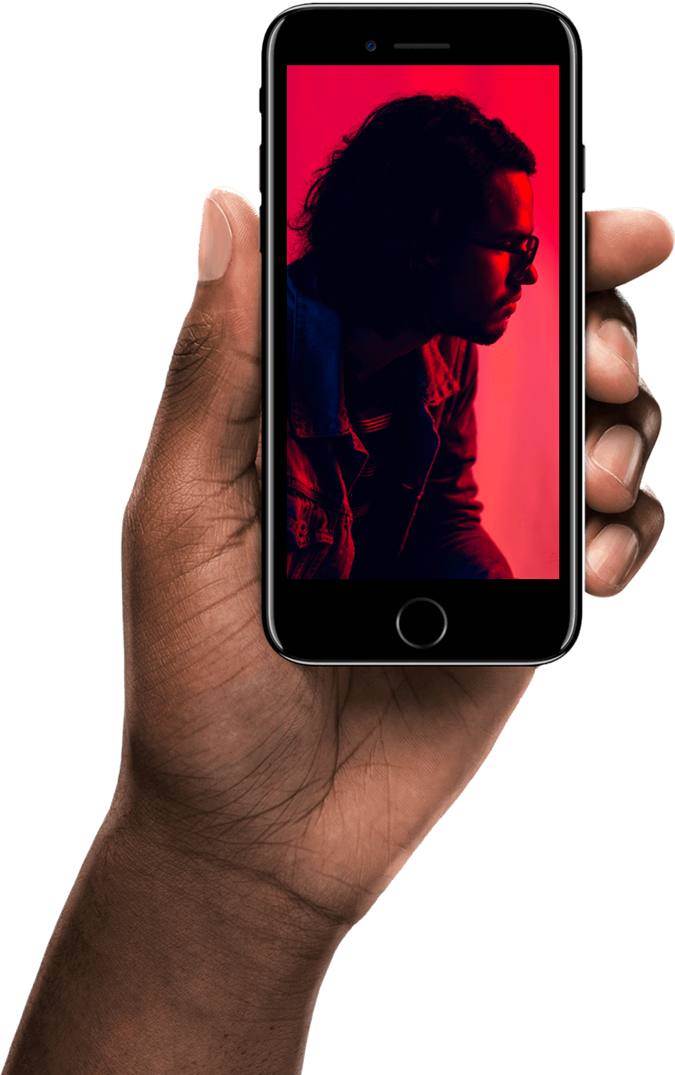 Dark-skinned hand holding a smartphone displaying a side-profile portrait of a man with glasses against a red background.