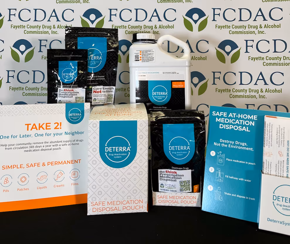 Deterra safe medication disposal pouches and container displayed on a surface with FCDAC backdrop.