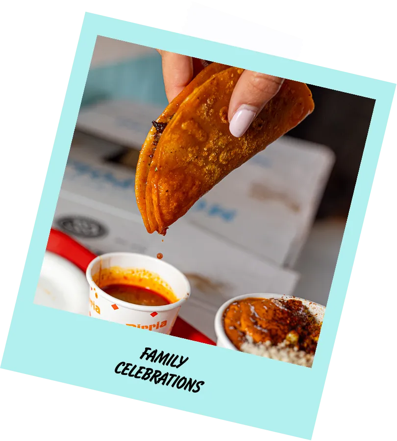 A person is holding a taco over a bowl of soup.