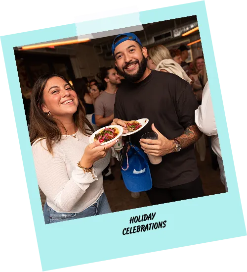 A man and a woman are holding plates of food and smiling.