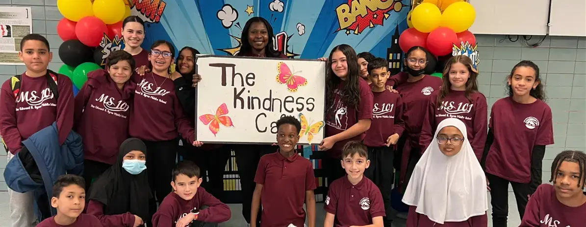 MS 101 students and teacher holding a Kindness Cafe sign