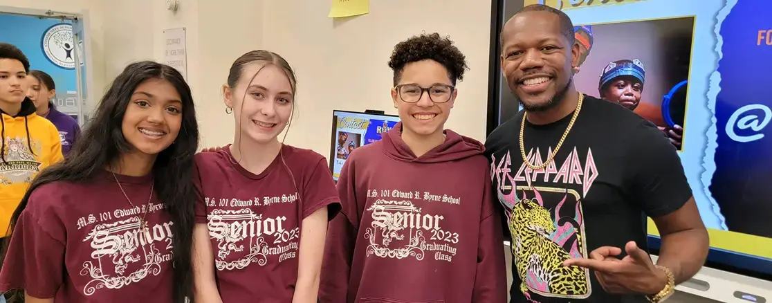 Three MS 101 senior students posing with smiling adult staff member