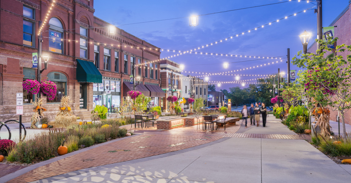 Downtown storefronts with string lights at dusk