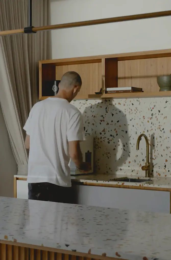 Homeowner in a terrazzo kitchen inside an Altereco2 home