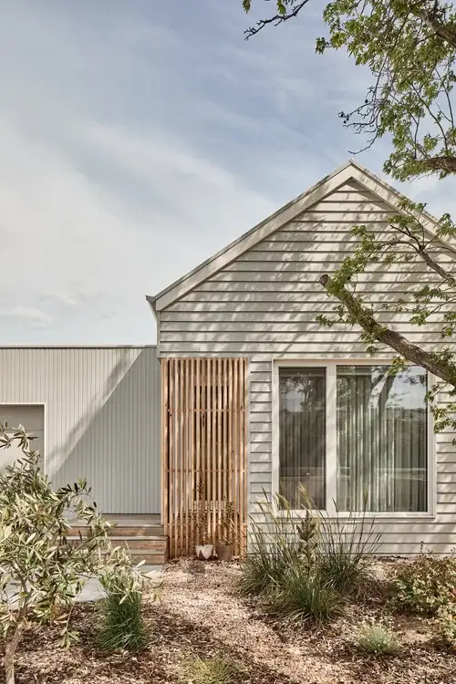 Light-clad Altereco2 home with timber screen and native garden