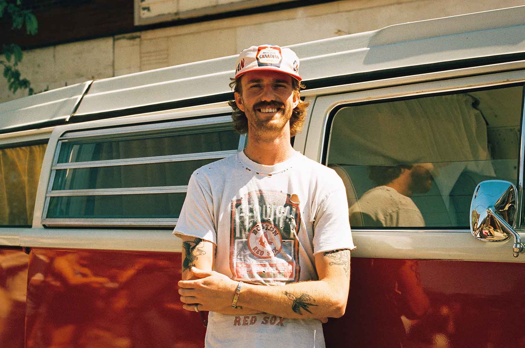 Person leaning against a vintage van at Do West Fest