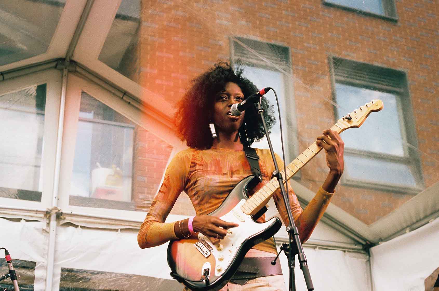 Musician singing into a microphone on stage at Do West Fest