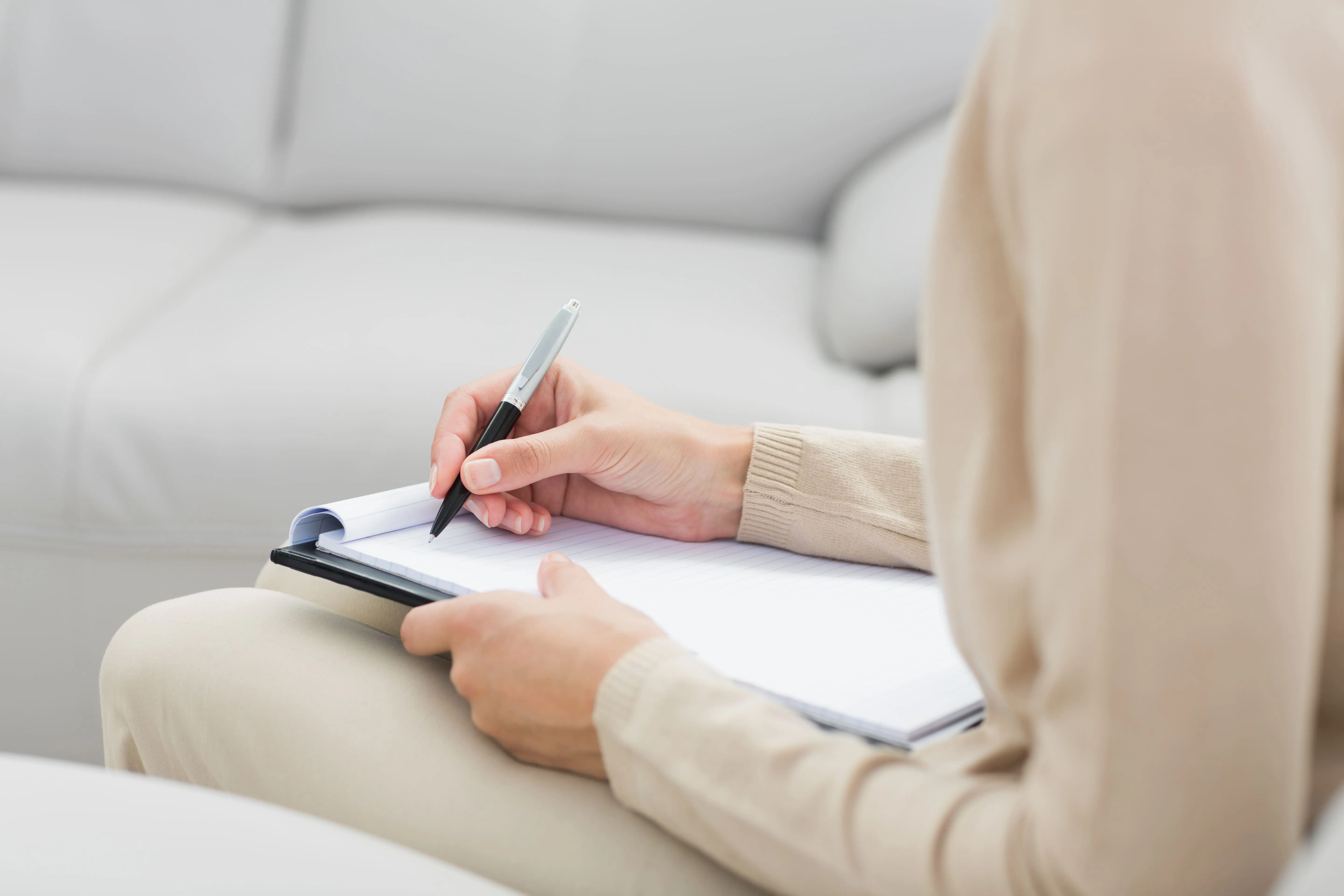 Therapist taking notes during an individual therapy session.