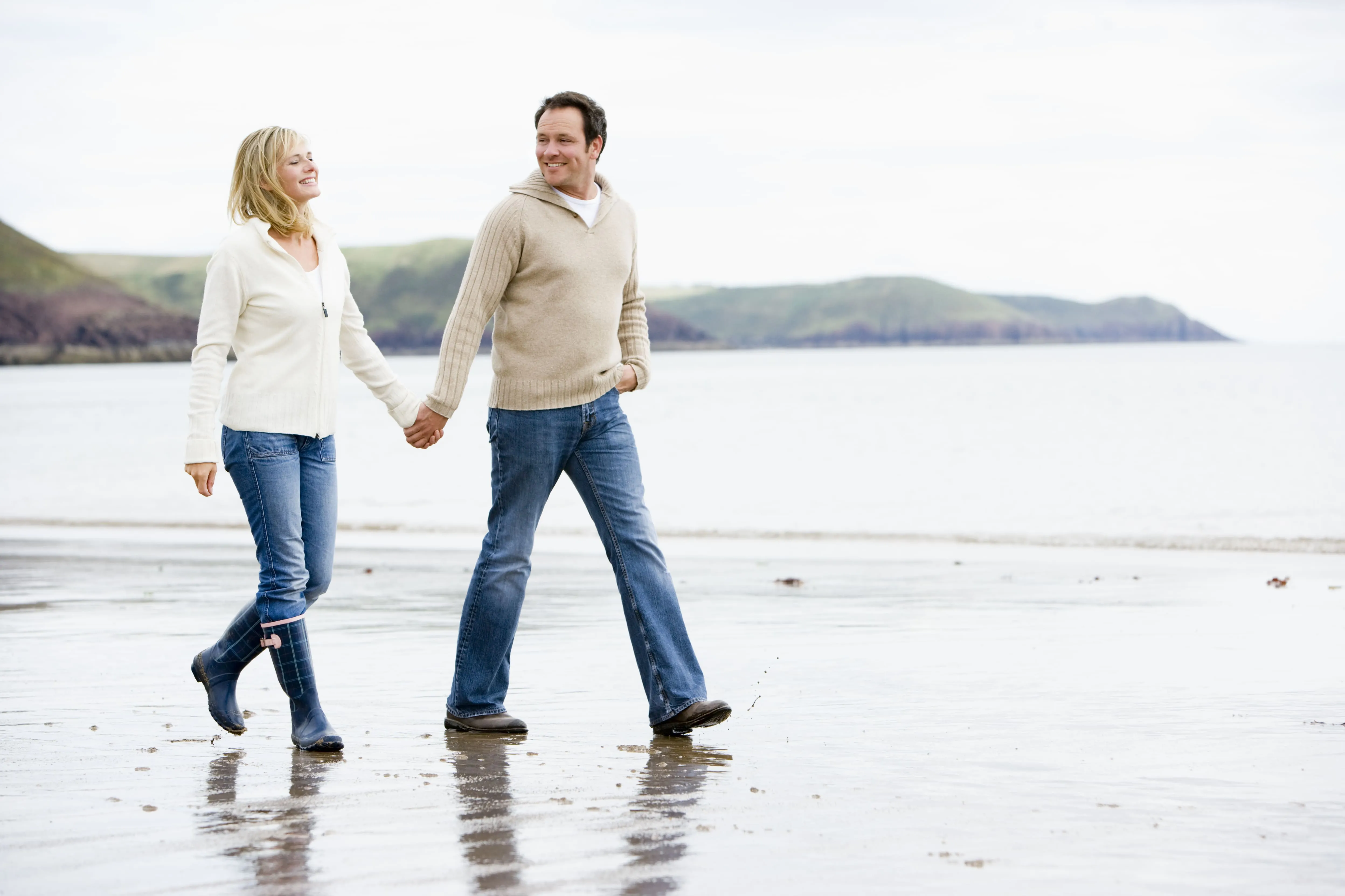 Couple walking together on a beach.