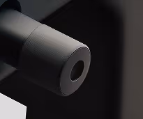 Close-up of a black cylindrical object with a hollow center against a dark background.