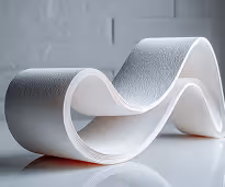Modern white sculptural bench with smooth, flowing wave-like curves on reflective floor.