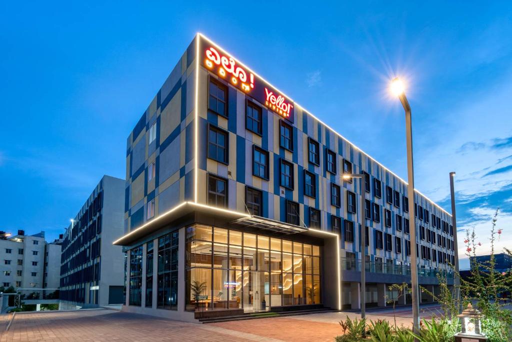 Yello coliving building in Bangalore lit up at dusk