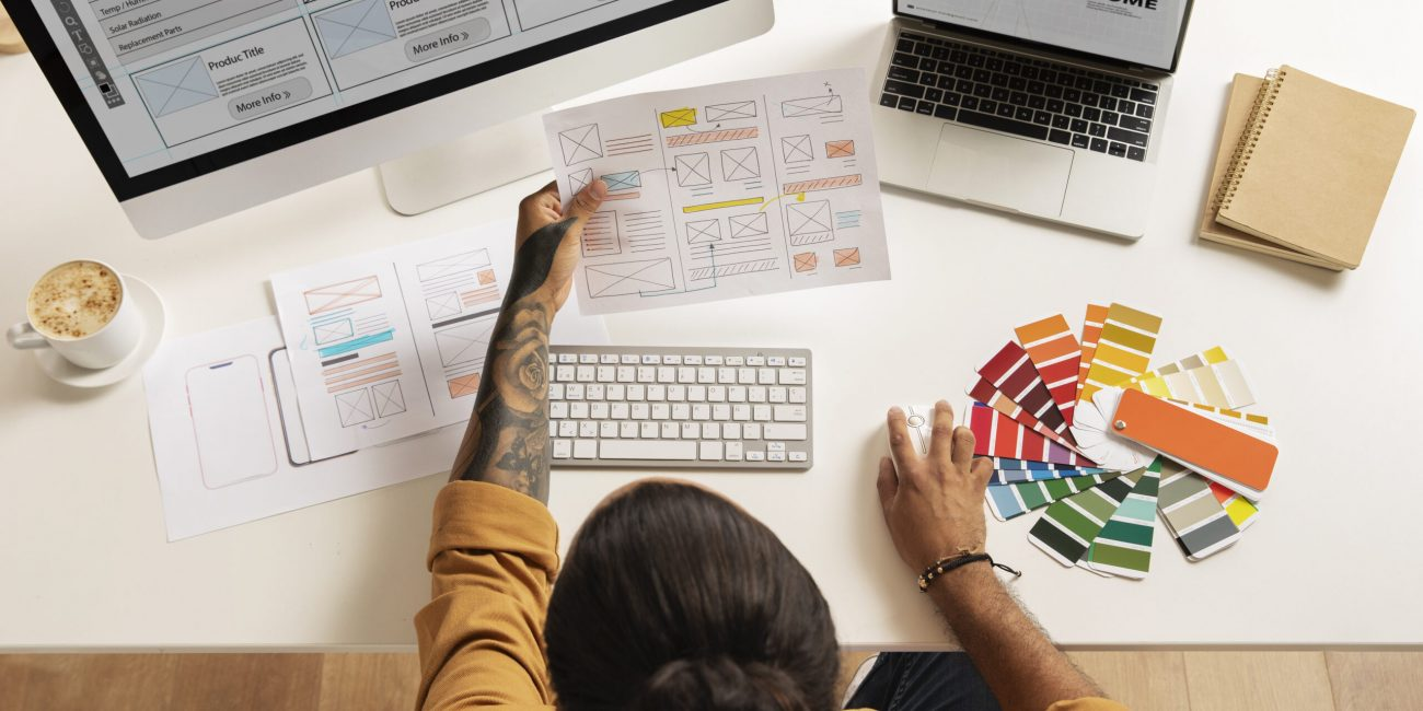 Designer sketching a landing page wireframe with colour swatches