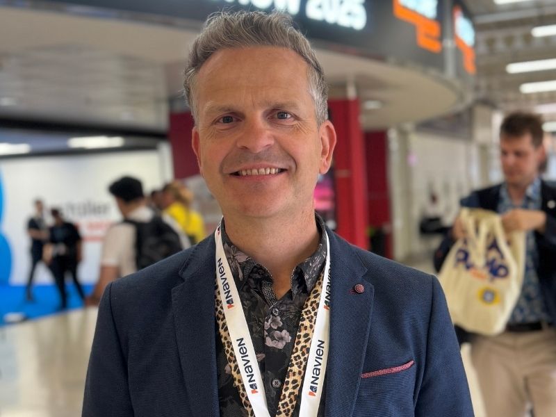 Anthony Tattum smiling at a marketing conference, wearing a blazer and speaker lanyard