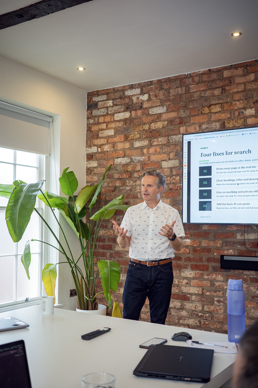 Anthony Tattum presenting to a workshop in front of a brick wall