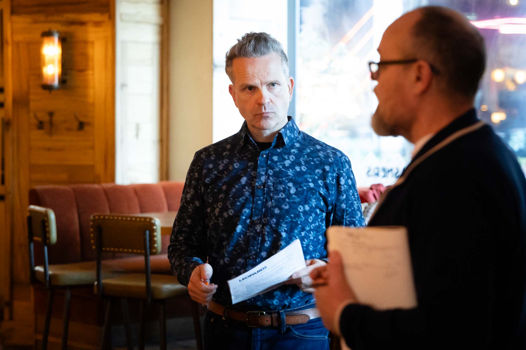 Anthony Tattum in conversation with a client, papers in hand