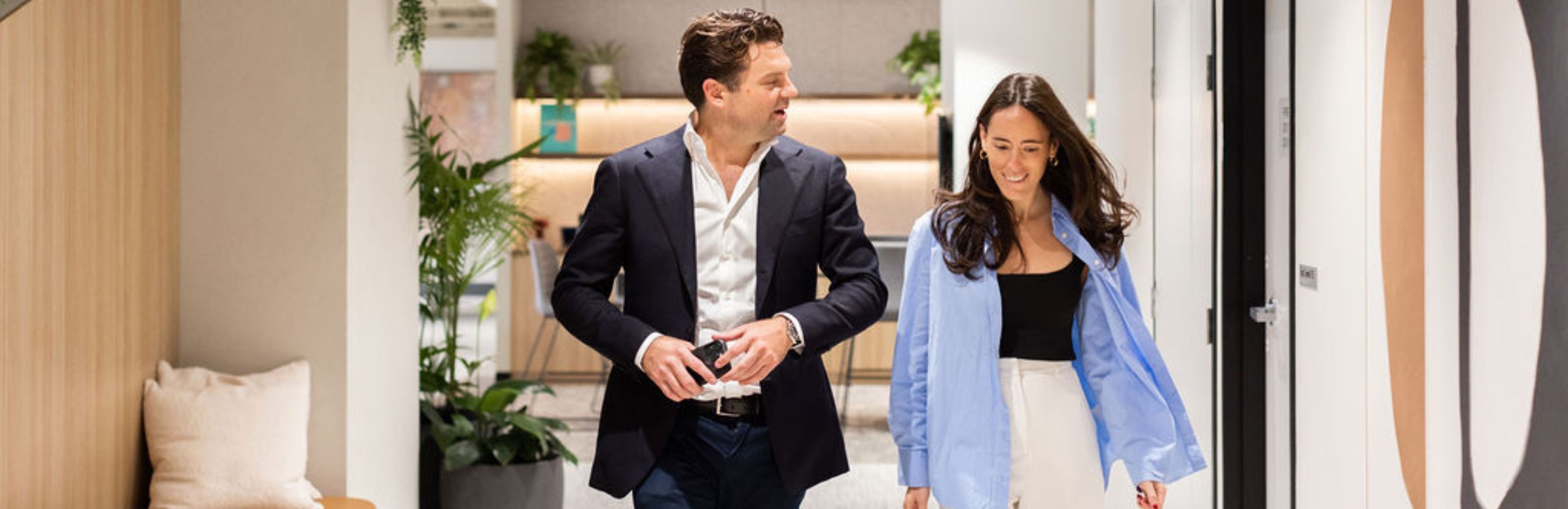 image of maxwell vaughan and ella segal walking through an office space