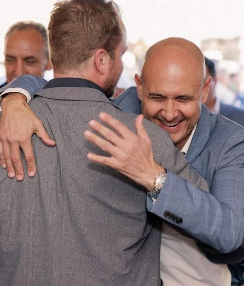 Image of our managing director hugging an acquaintance at an event