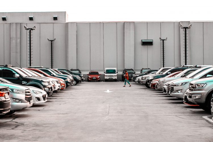 A person walking through a staff car park | Car parking article