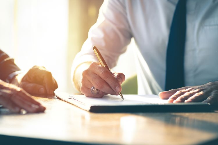 Close up of man signing a contract illustrating negotiating the right to assignment or sublease