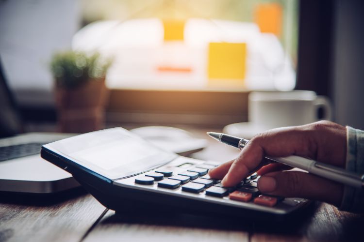 someone using a calculator to calculate rent and incentives off the back of our commercial leasing checklist