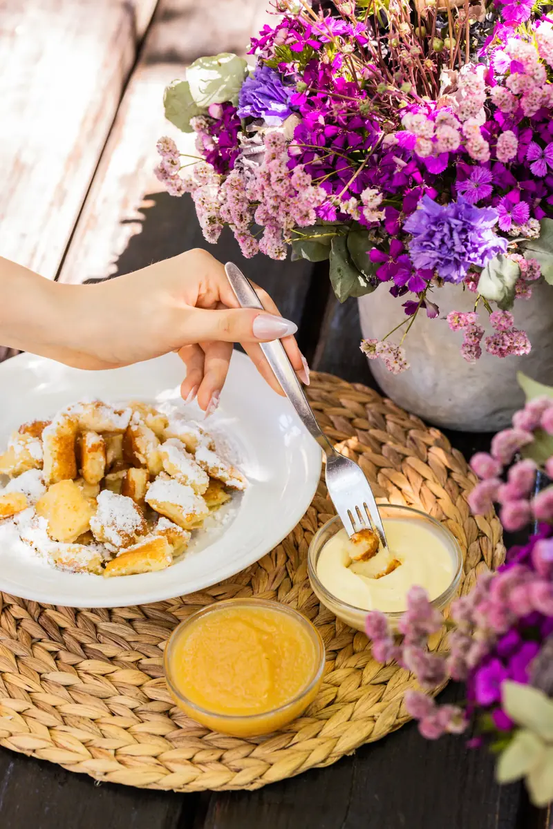 Frittierte Snacks mit Dip und Blumendeko auf einem Tisch im Uferstüble