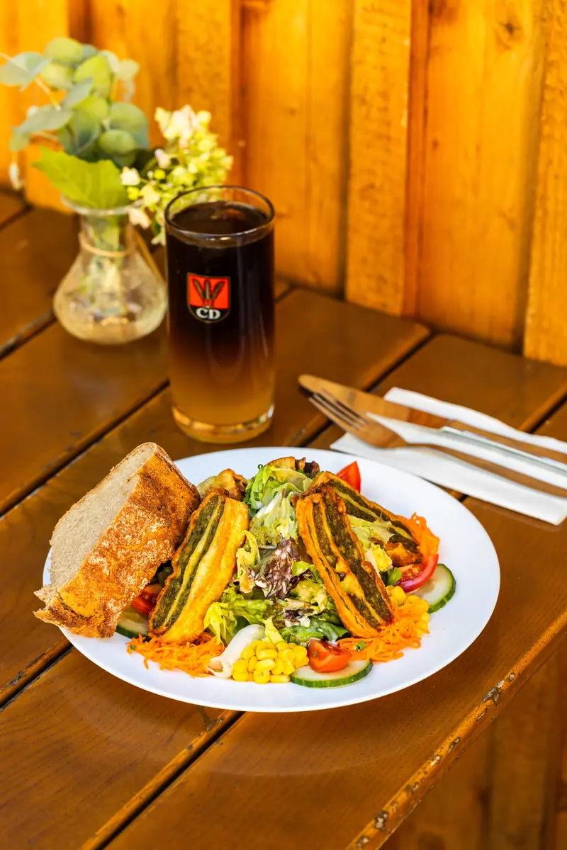 Wrap mit Salat und ein Glas Bier auf einem Holztisch im Uferstüble