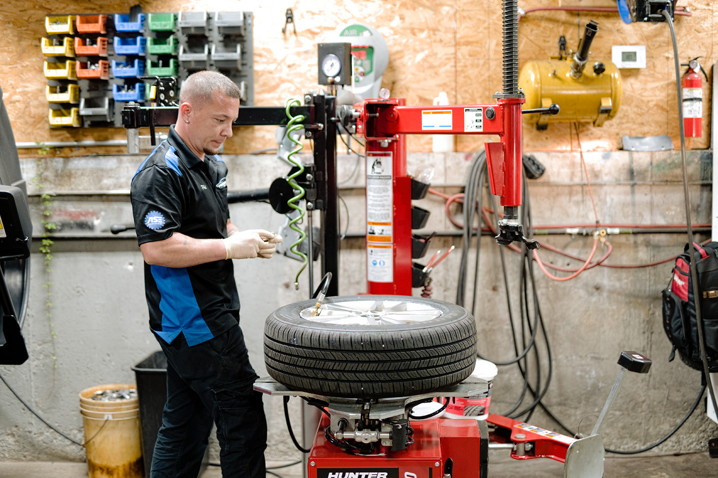 ASE-certified technician mounting a new tire using professional tire service equipment at Primary Care Auto Repair.