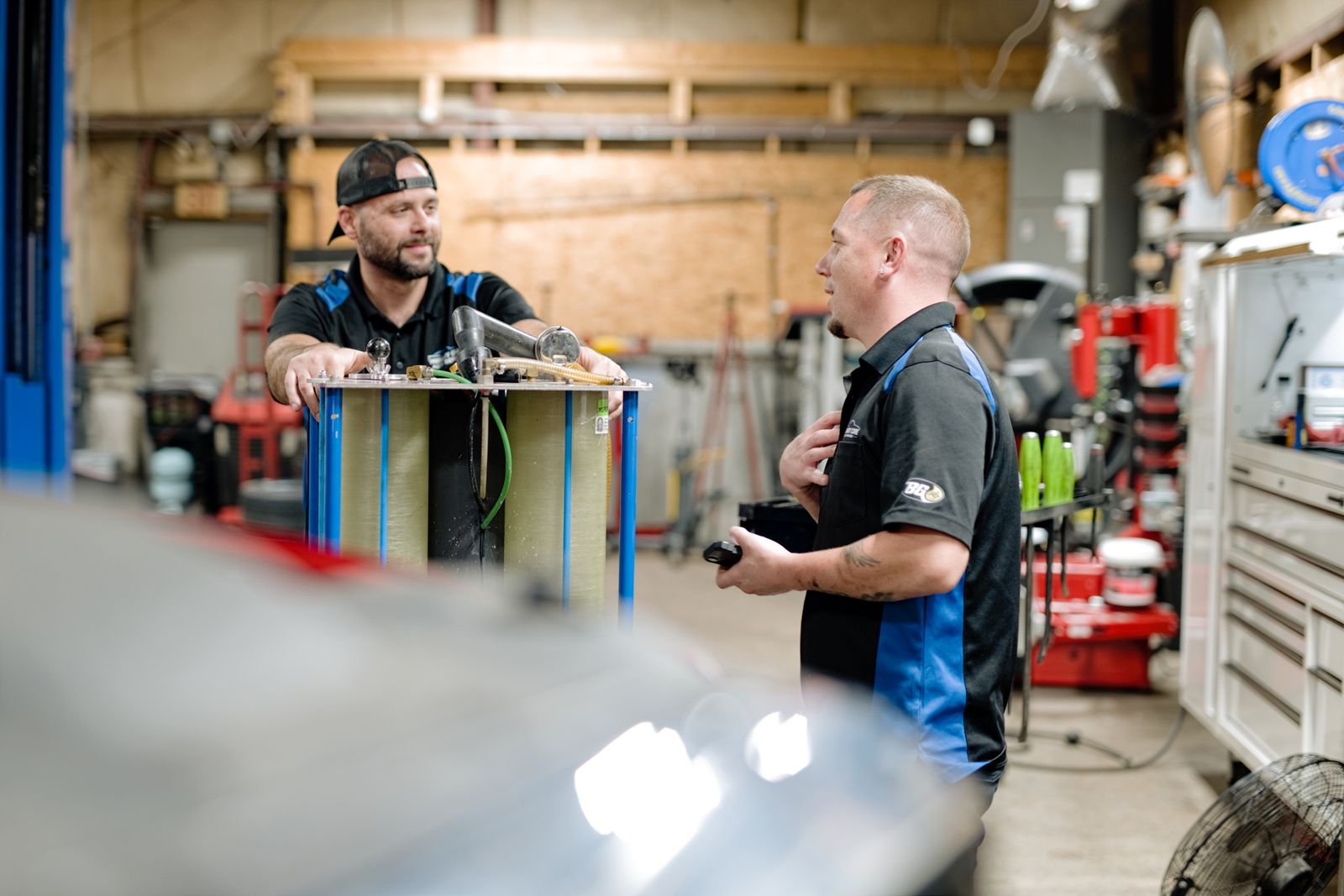 Two Primary Care Auto technicians talking in the service bay