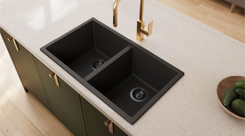 Black double-bowl kitchen sink with brushed-brass mixer in a pale benchtop.