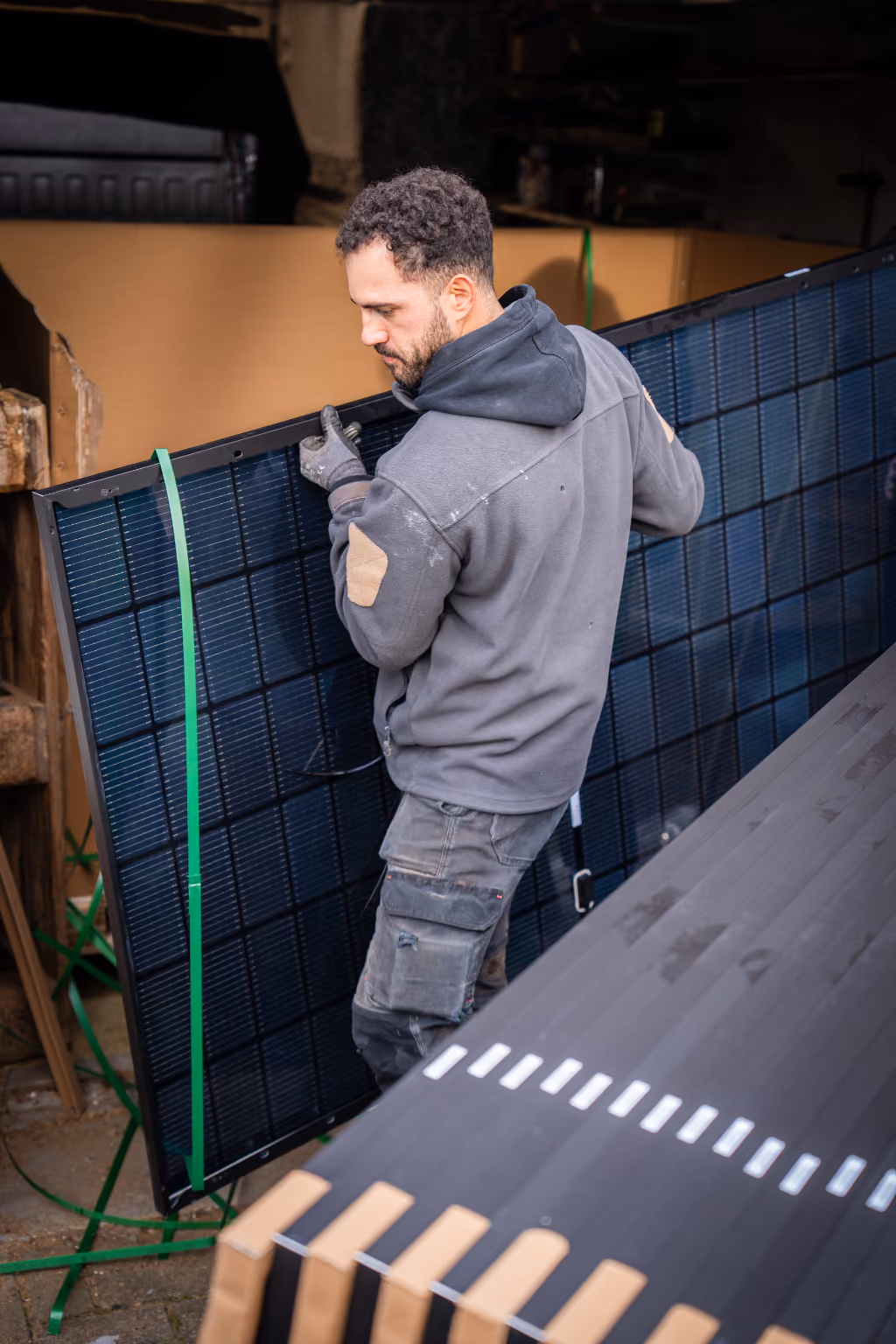 Mitarbeiter trägt ein Solarmodul für die Installation einer Solaranlage in Stadtallendorf