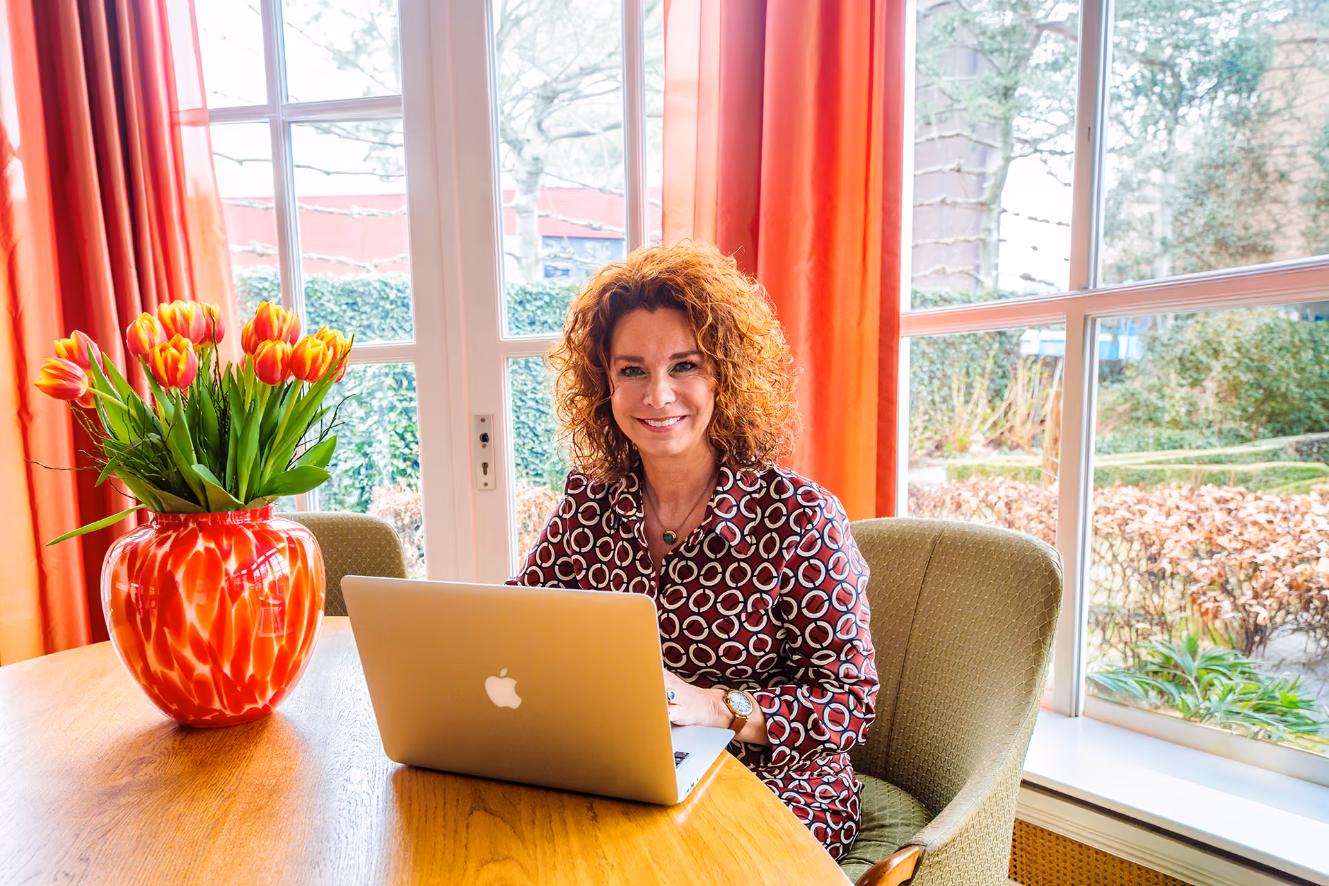 Kleurrijke foto van Gerda Wijnen achter haar labtop