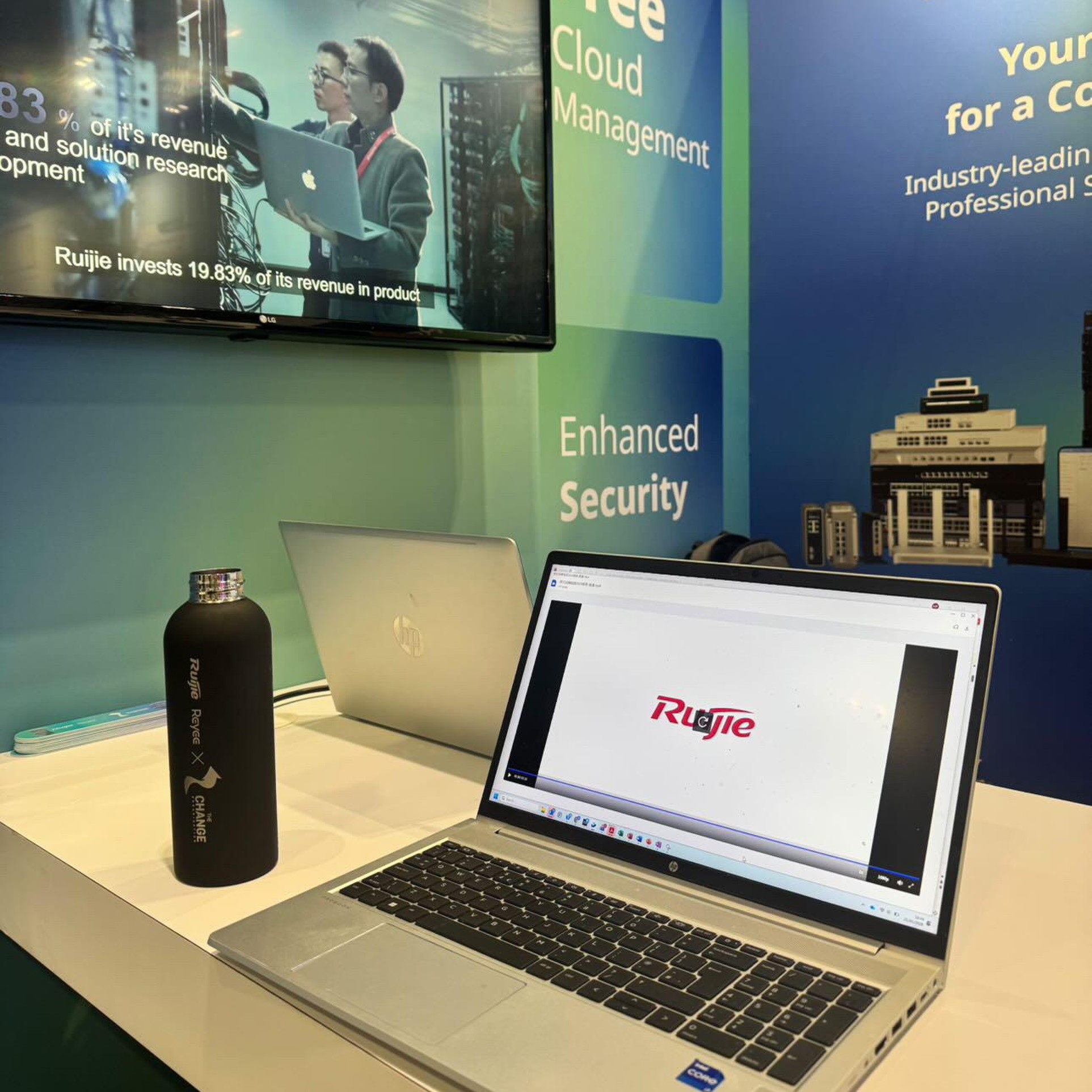 Laptop demo of Ruijie cloud management on the stand, next to a branded water bottle