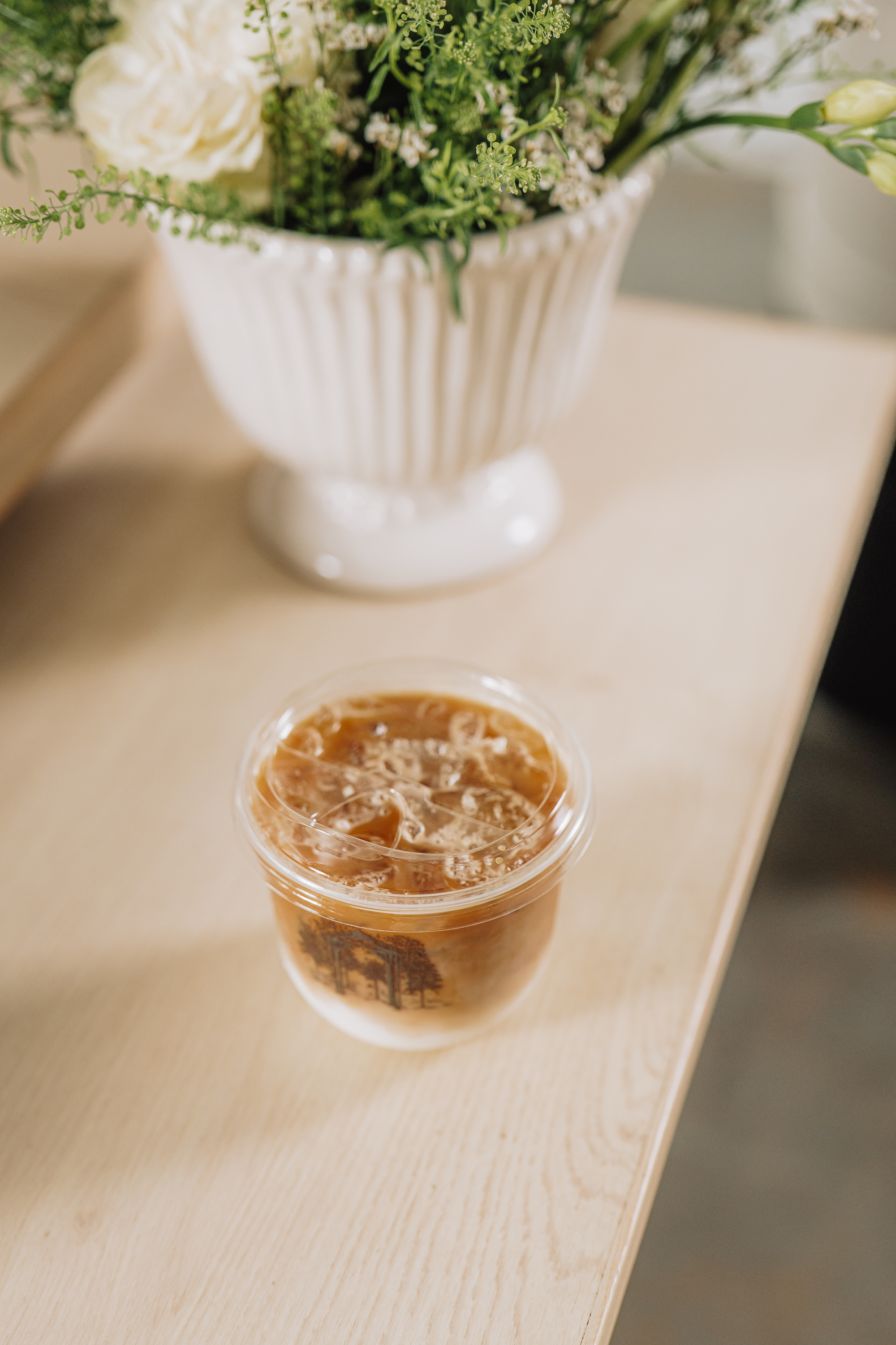 Iced coffee beside white wedding florals at a Wendell reception