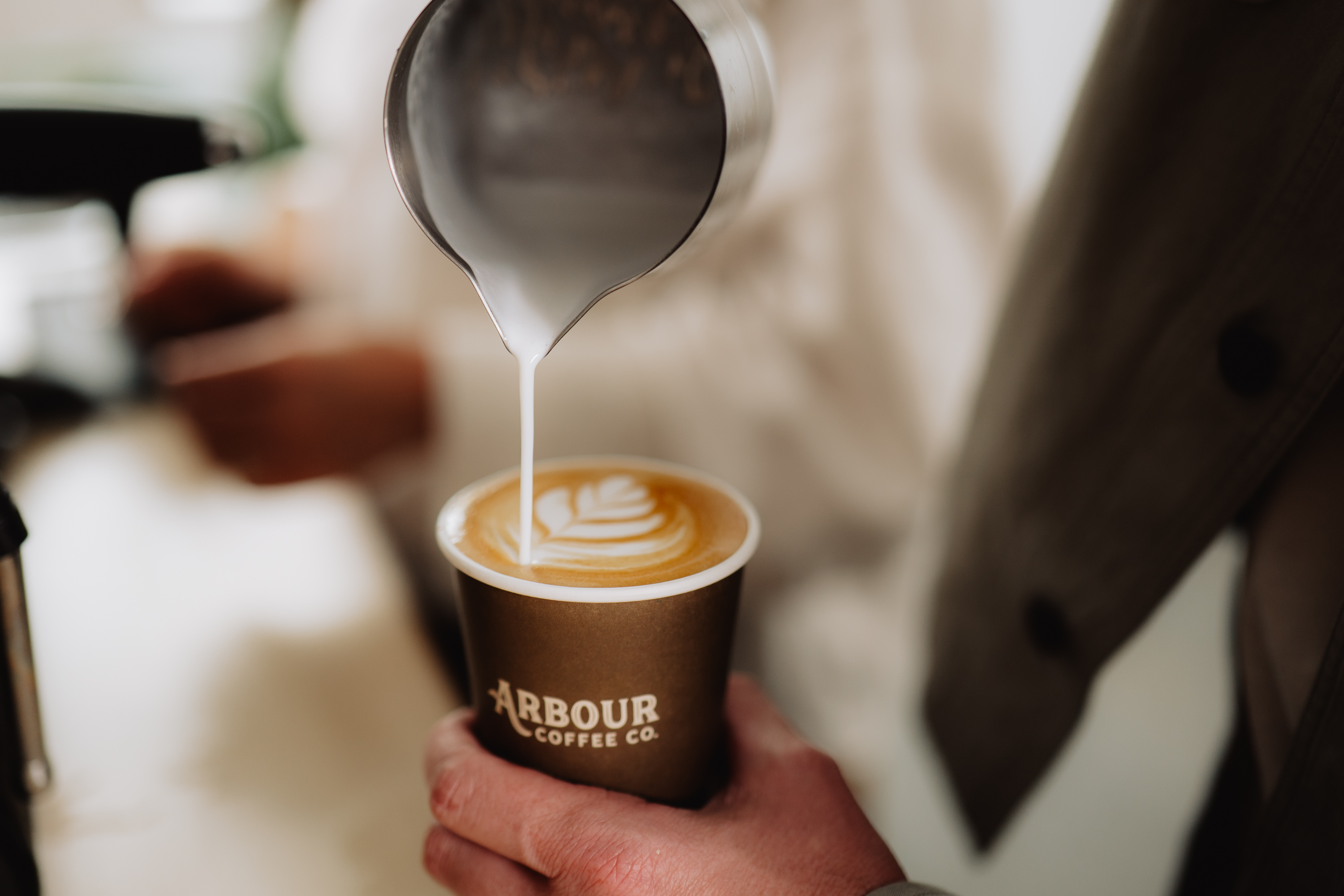 Barista pouring a handcrafted latte at a private party in Wendell