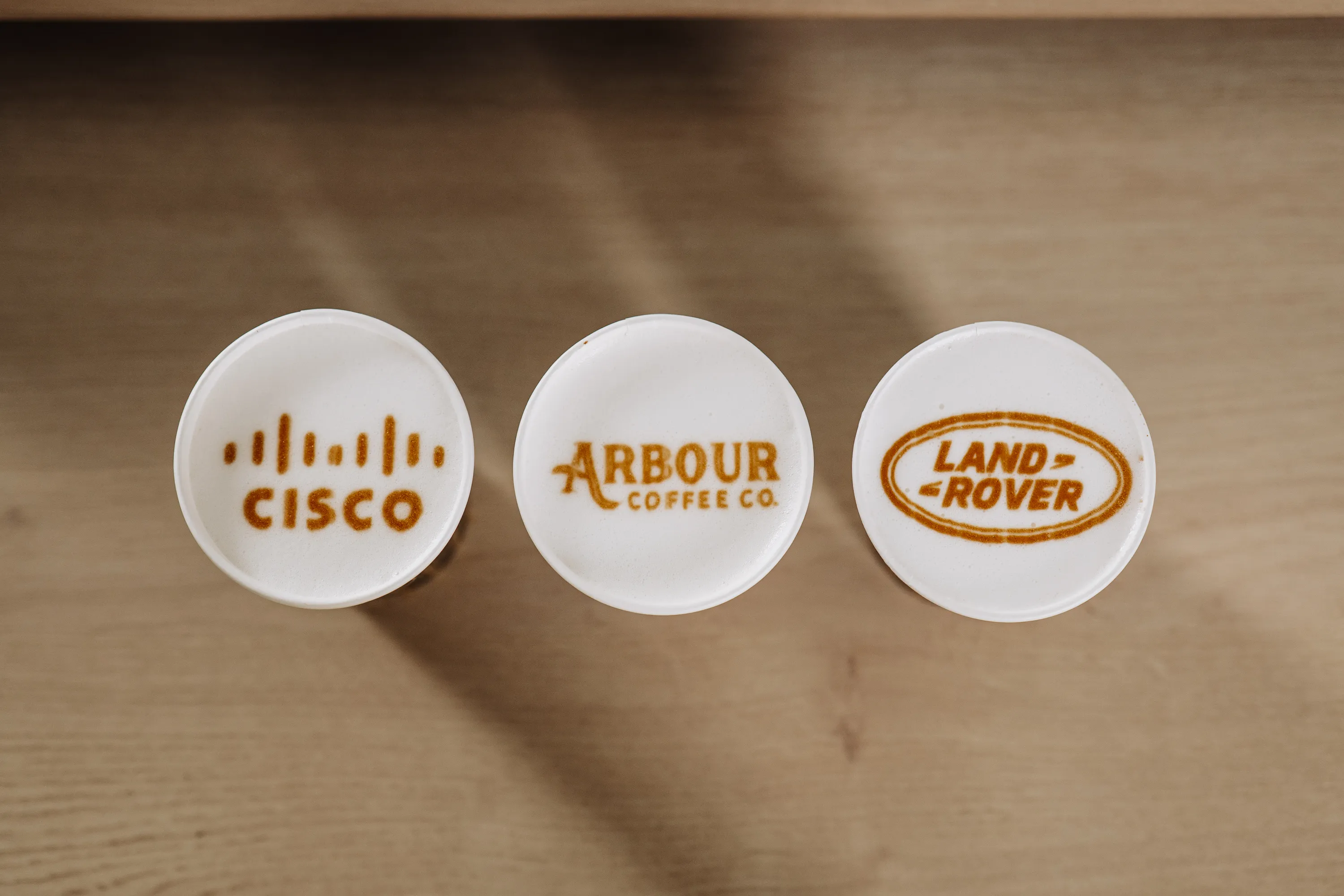Lattes topped with corporate logo latte art at a Wilmington company event