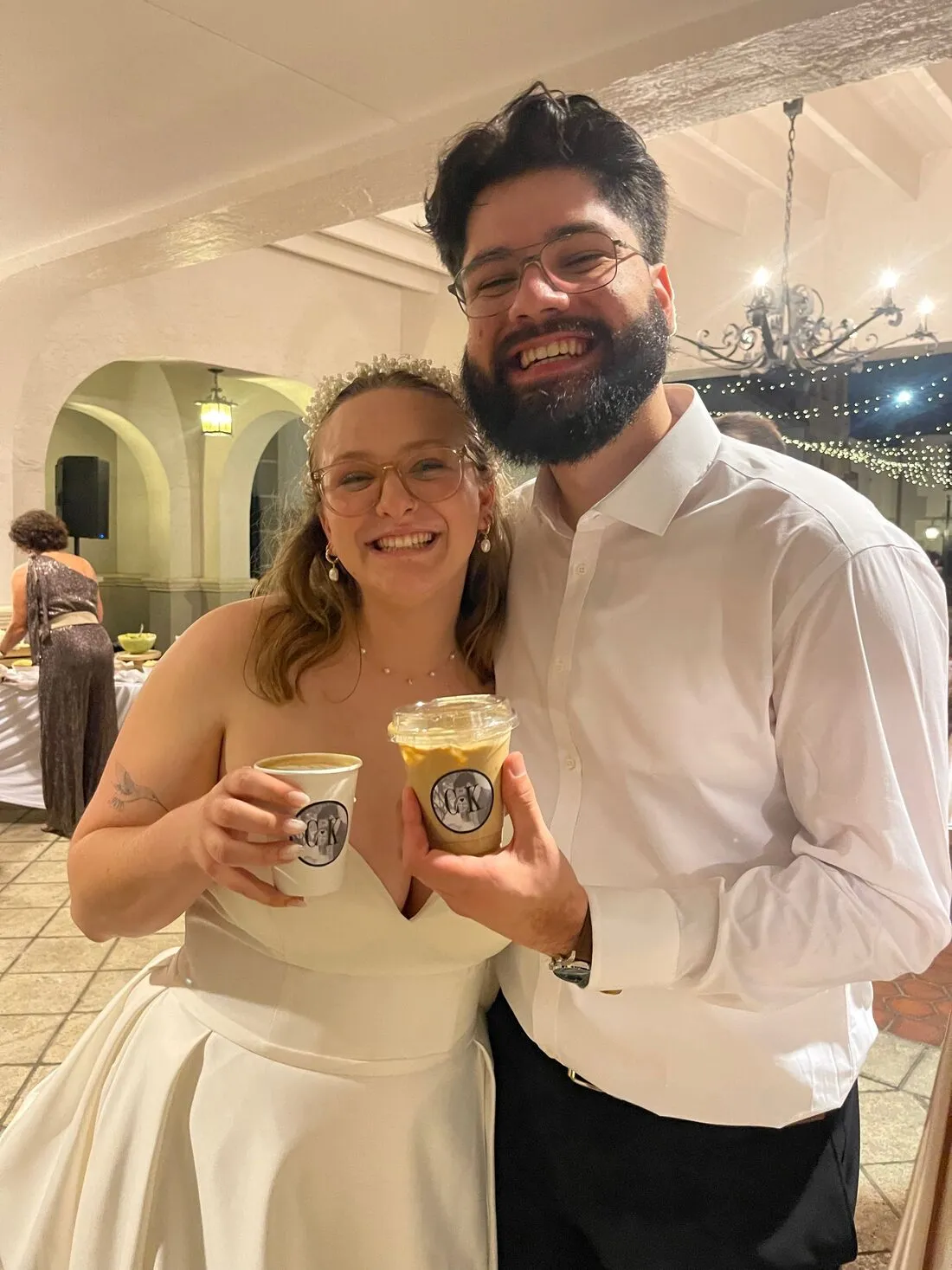 Newlyweds smiling with their Storii Coffee drinks at the reception