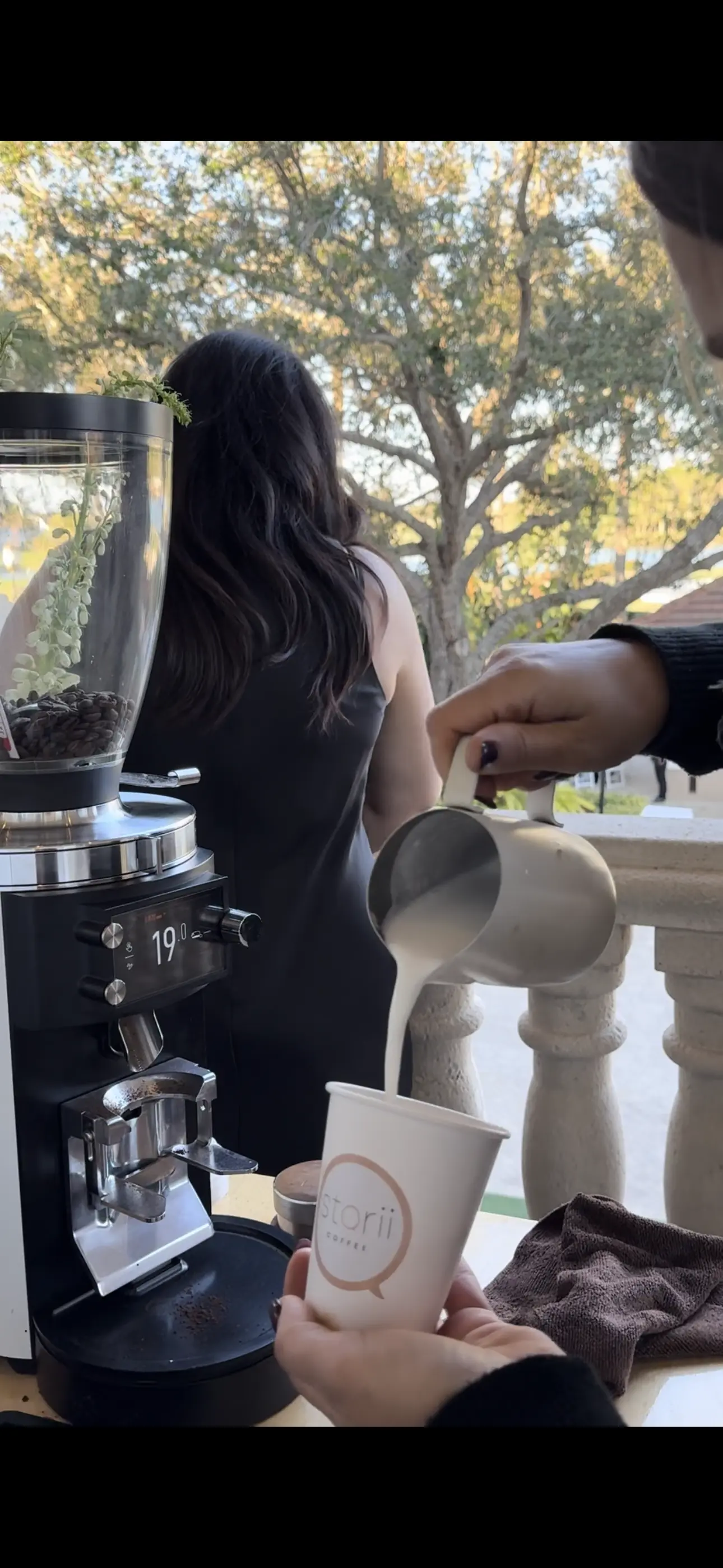 Steamed milk poured into a Storii cup behind the cart