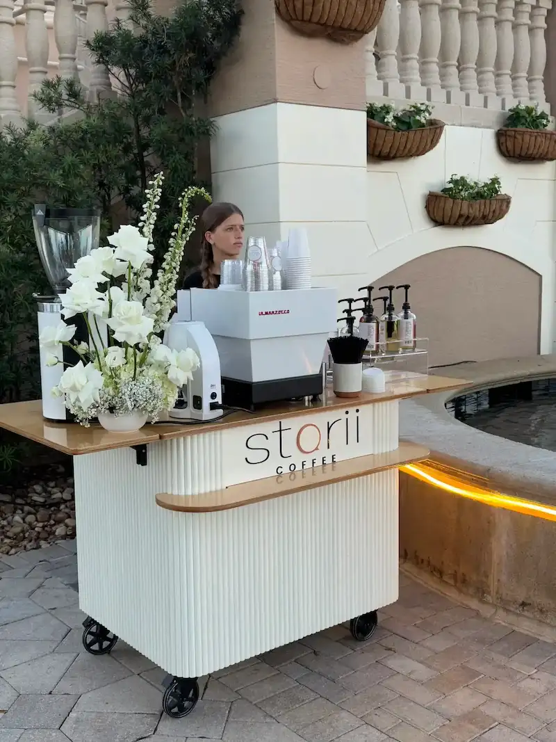 Storii Coffee cream espresso cart styled with white florals at a poolside Florida event