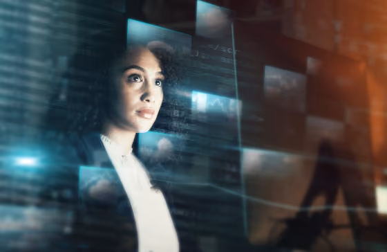 Femme regardant des écrans numériques et graphiques dans un environnement futuriste flou.