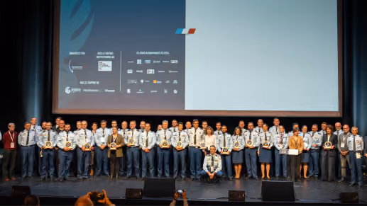 Groupe de personnes debout sur scène lors d'une cérémonie de remise de prix officielle.