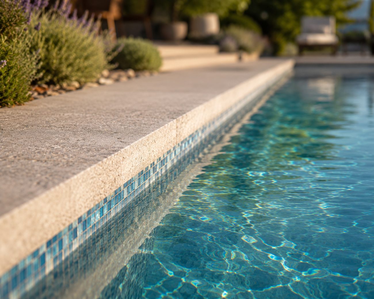 Margelle en pierre naturelle et mosaïque bleue d'une piscine haut de gamme
