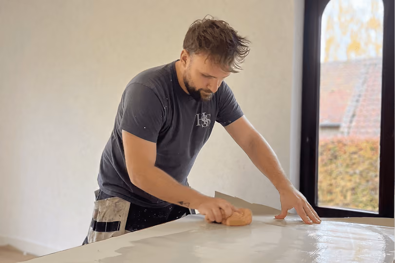 Professional wallpaper installer at work.