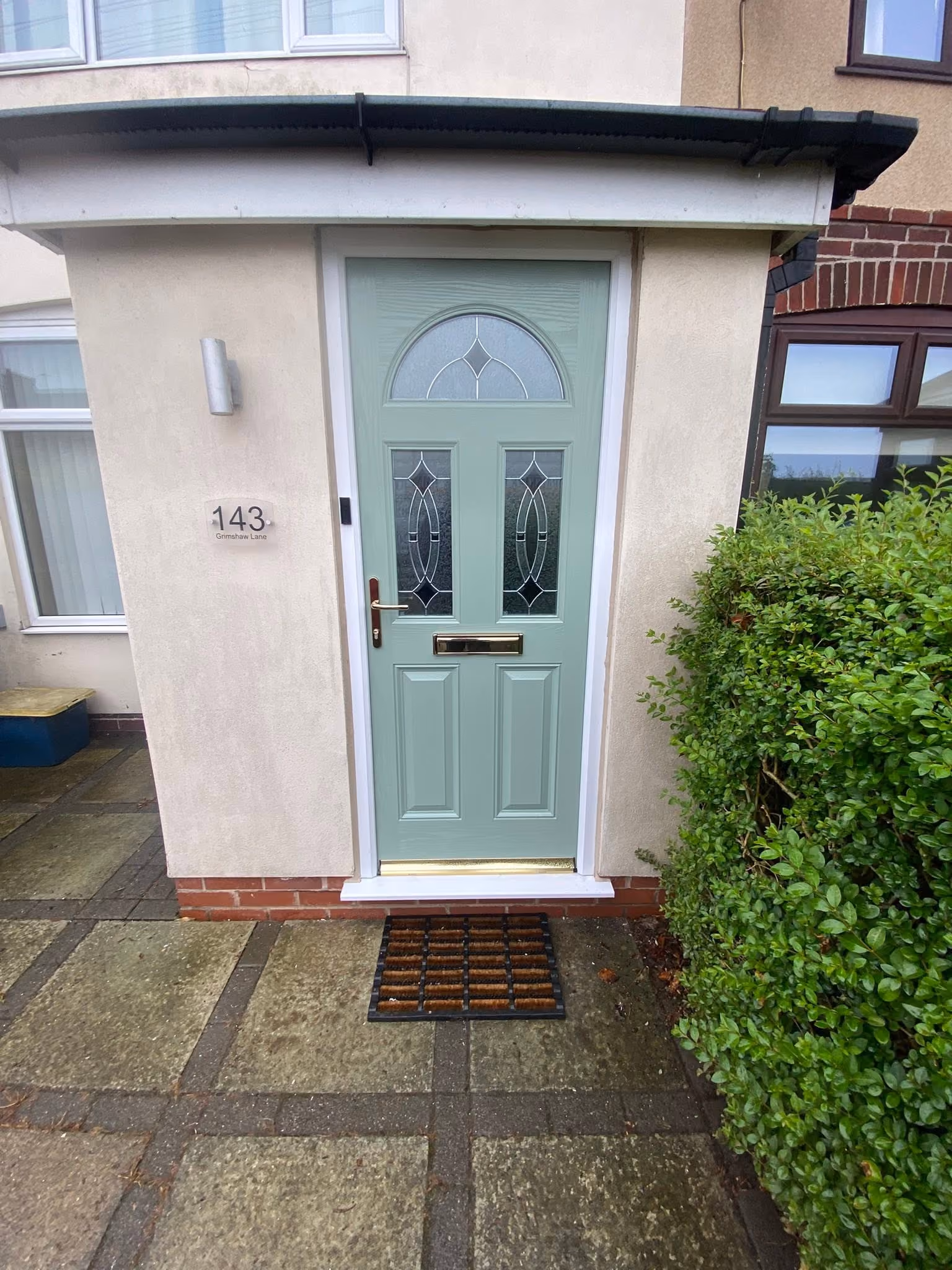 New sage green composite front door with sunburst glazing and brass furniture fitted in Ormskirk