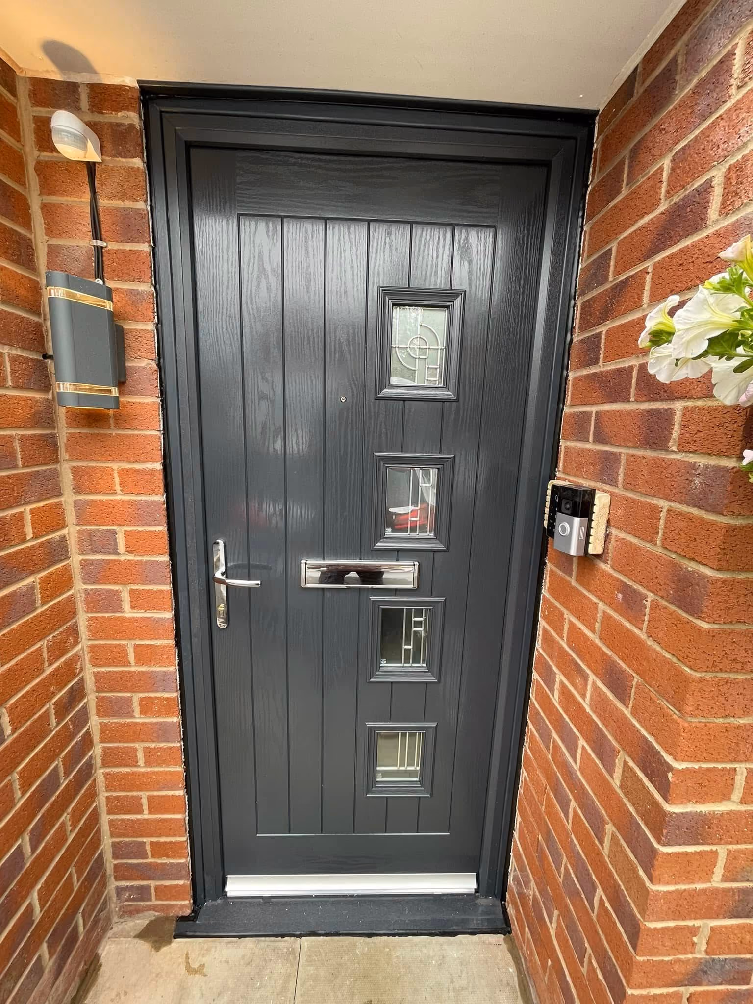 Anthracite grey composite front door with four square decorative glazed panels and chrome furniture fitted in Ormskirk