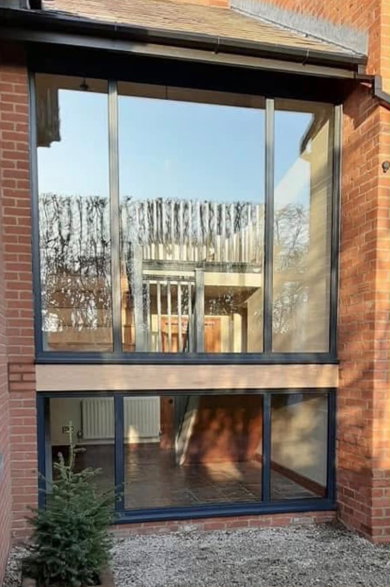 Large anthracite grey aluminium picture window spanning two storeys on a brick home near Ormskirk.