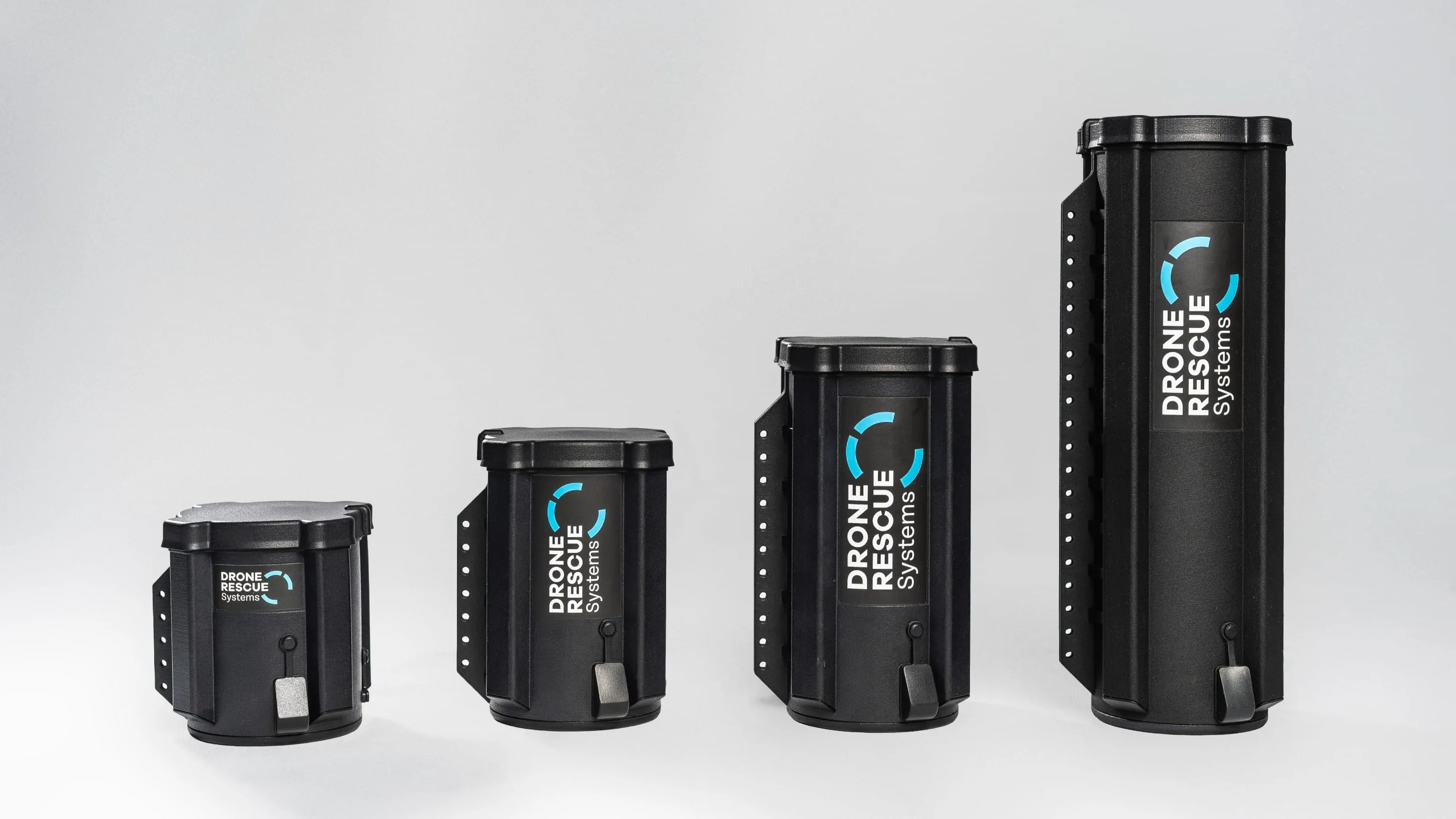 Four black Drone Rescue Systems containers in increasing sizes on a gray background.