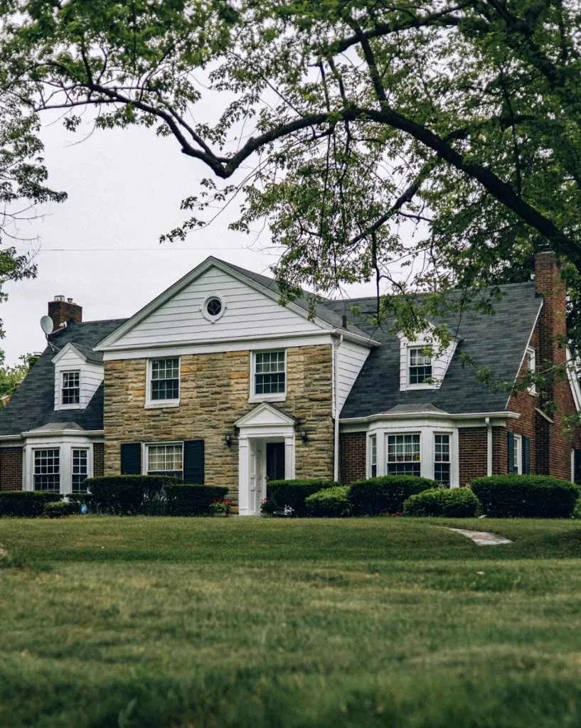 Stately two-story stone and brick family home with manicured lawn, representing estate planning in Missoula