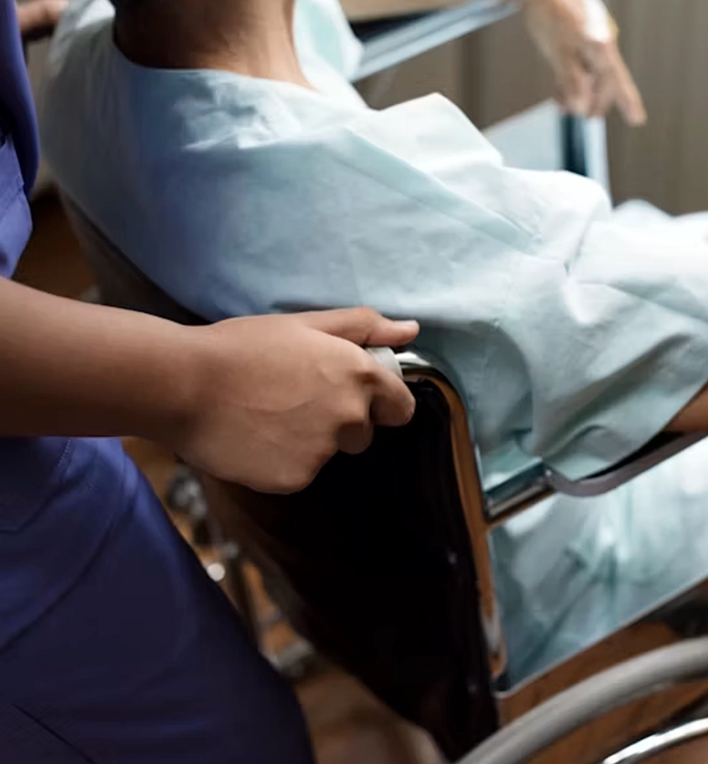 Healthcare worker pushing a patient in a wheelchair through a medical facility, representing medical care and compensation available in personal injury cases in Missoula, Montana